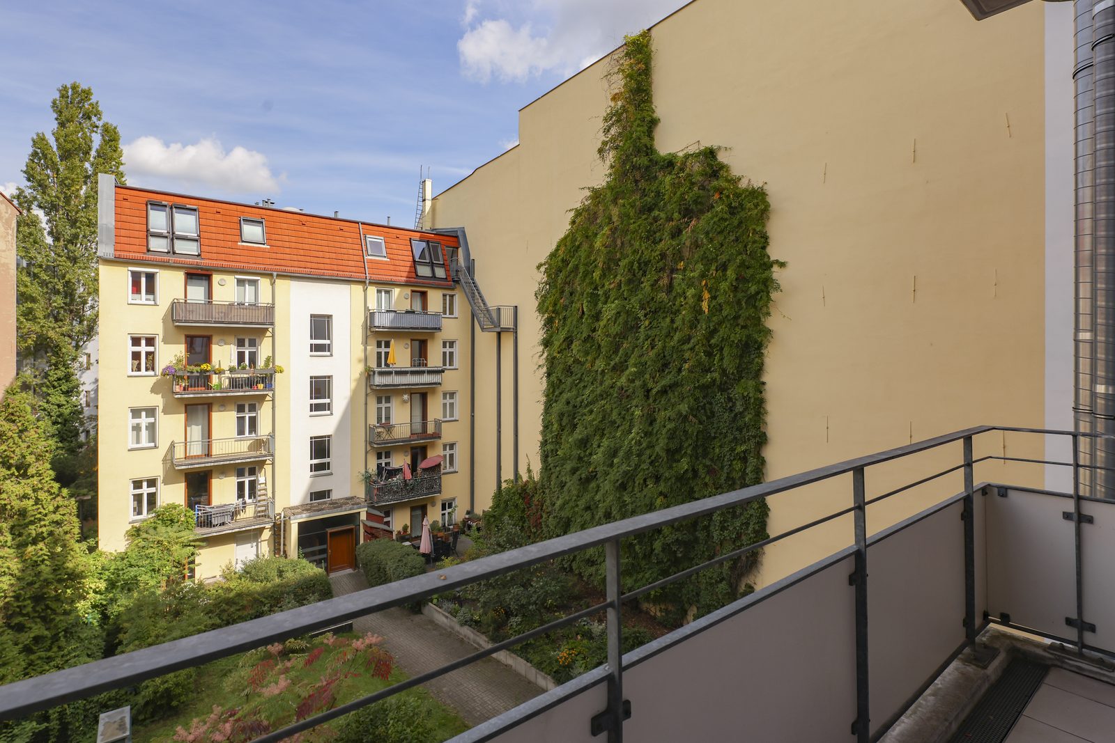 Blick vom Balkon in den grünen Hof